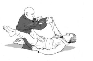 A black belt breaks a stunned white belt's grip, leaving his hand and wrist clinging to the black belt's gi.